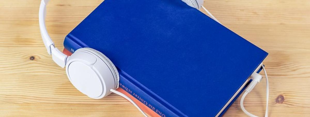 a blue book with headphones resting on top.