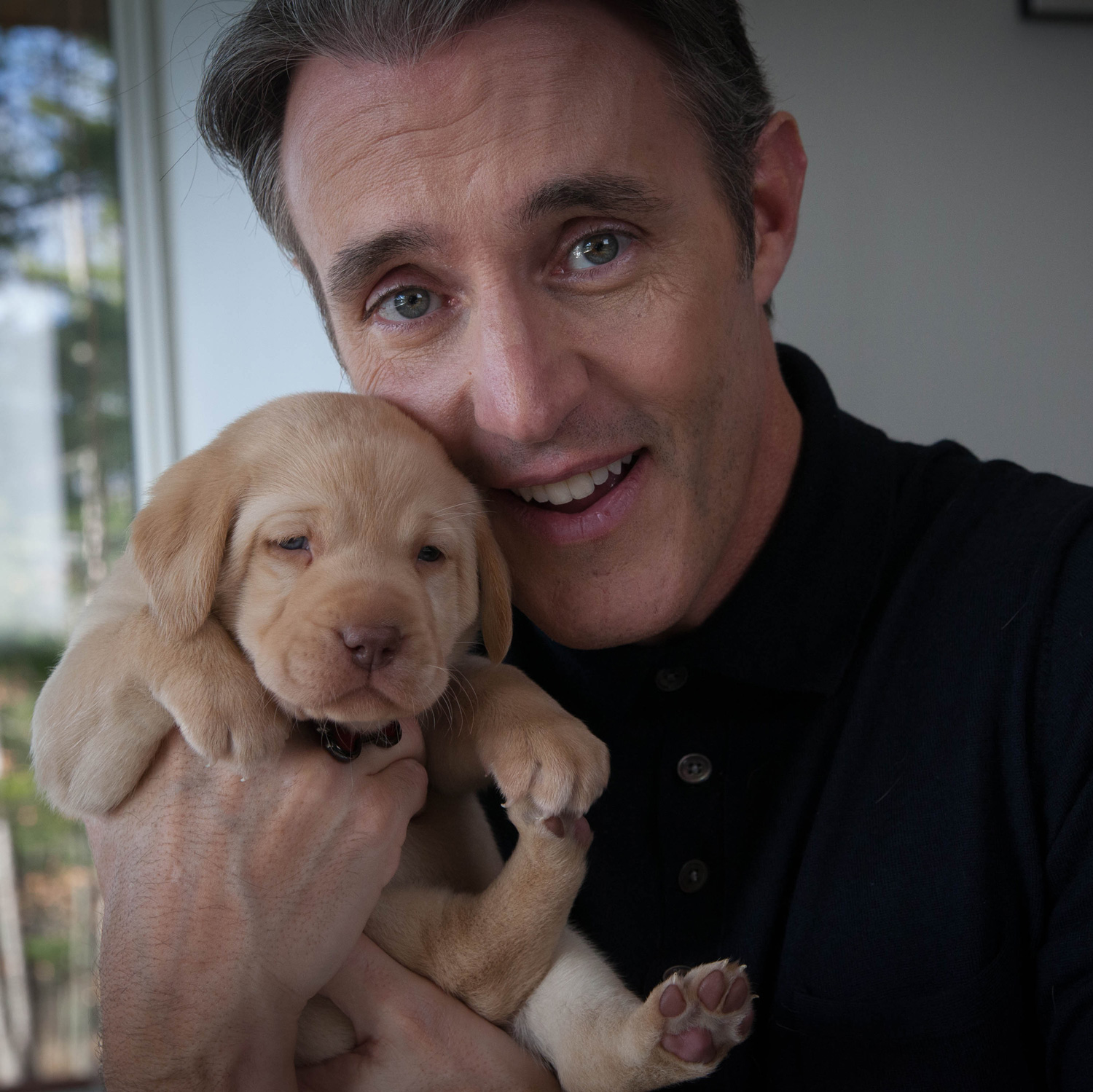 CNIB Ambassador Ben Mulroney holding a puppy