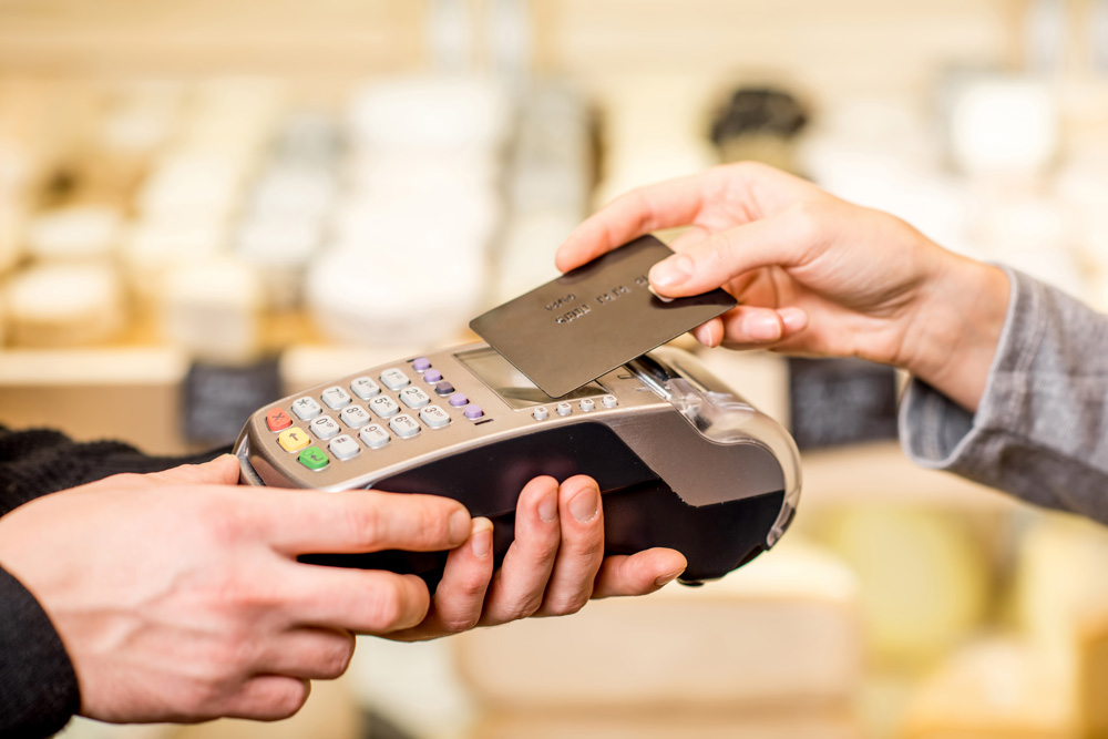 Person tapping credit card on payment terminal