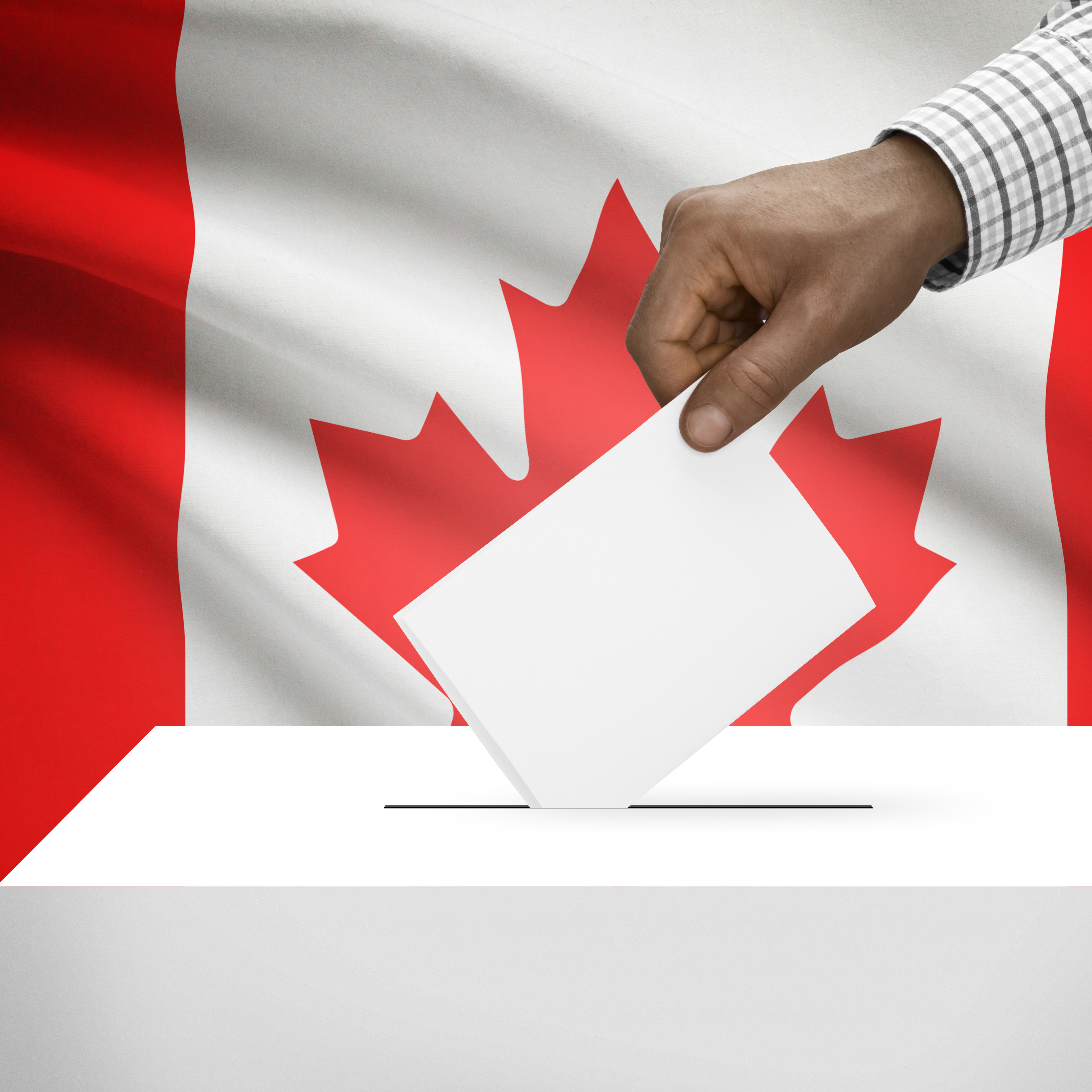 Une personne déposant son bulletin de vote dans une urne. On voit un drapeau canadien en arrière-plan.