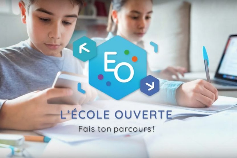 Deux enfant, un écrit l'autre est sur l'ordinateur avec le texte: L'école ouverte, fais ton parcours.