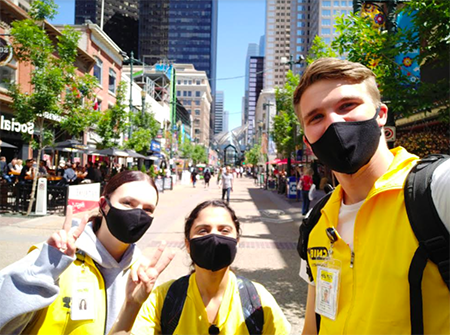 [10:01 a.m.] John Lalley Pic 4: 3 Three CNIB fundraisers wearing masks and bright yellow vests smiling as they greet, and flashing the peace sign with first and second fingers raised in a V shape  [10:02 a.m.] John Lalley Appreciate your help Sir