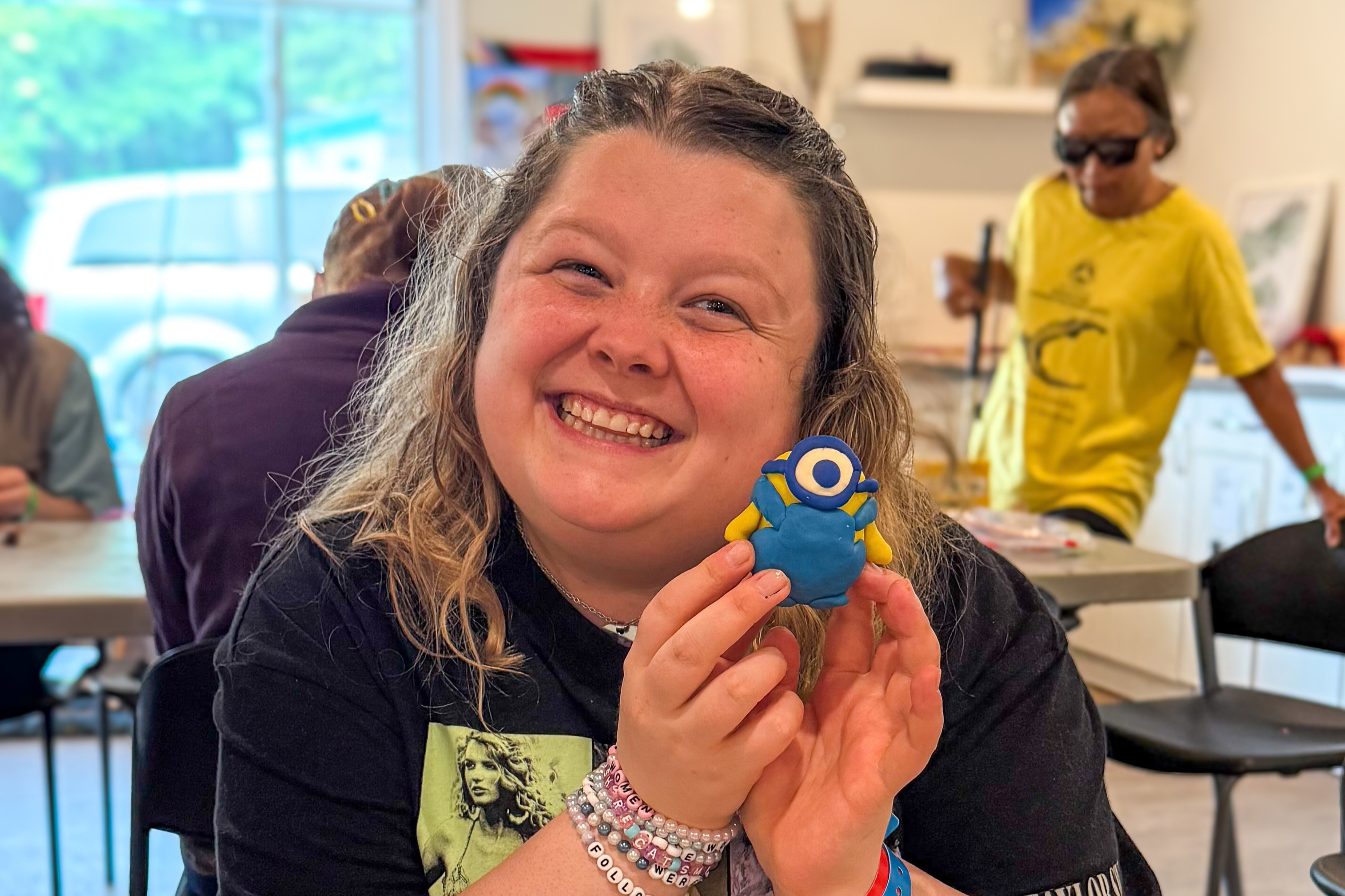 Alicia, une participante à la Semaine intensive d’arts pour jeunes adultes du Camp Lake Joe d’INCA sourit en brandissant une petite sculpture en argile qu’elle a réalisée.