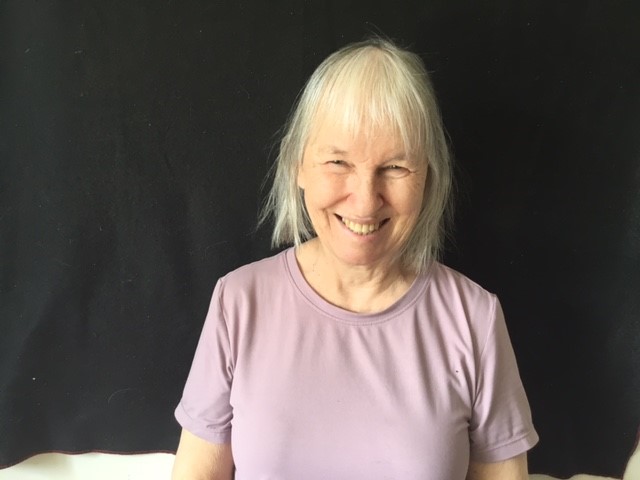 Une photo de tête de Brenda Macalister souriant devant un fond noir.