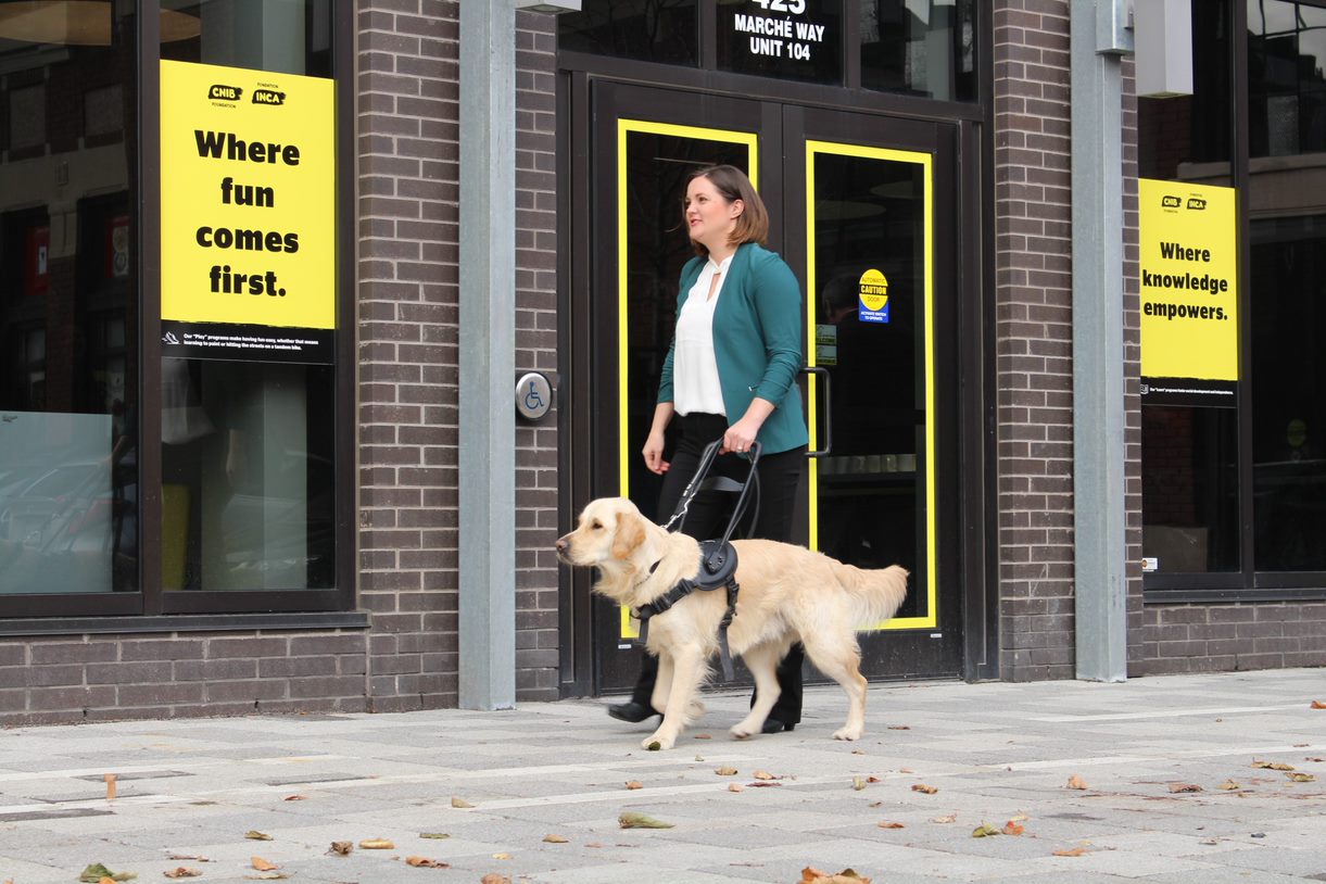 Photo de Erin et Winston marchant sur un trottoir devant un bureau de la Fondation INCA.