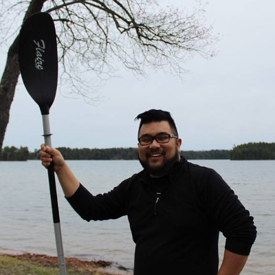 Eugene Chong holds a canoe paddle. 