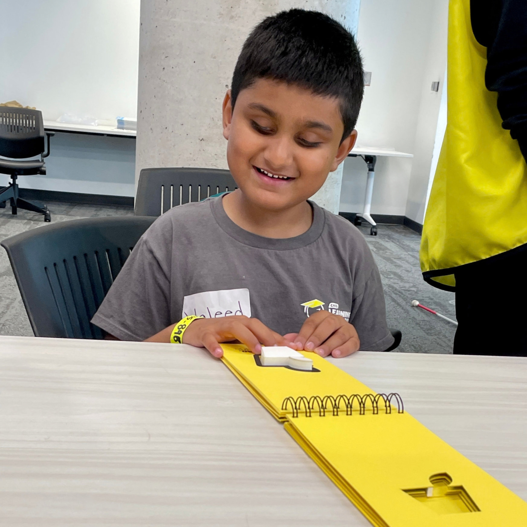 Un jeune garçon lisant en braille à L'Académie d'apprentissage d'INCA.