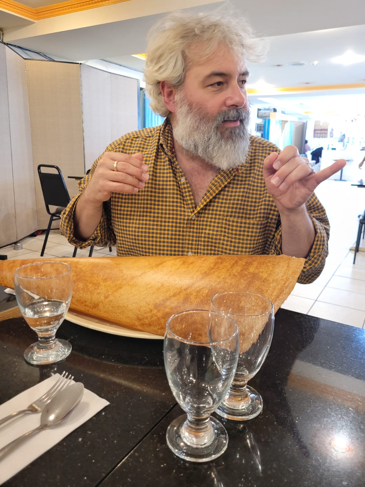 Inside the Udupi Palace restaurant, JJ Hunt enjoys a large dosa!