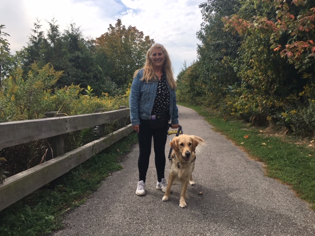 Photo de Lindsay et Charlie marchant le long d'un sentier dans un parc par une journée ensoleillée, souriant pour la photo.