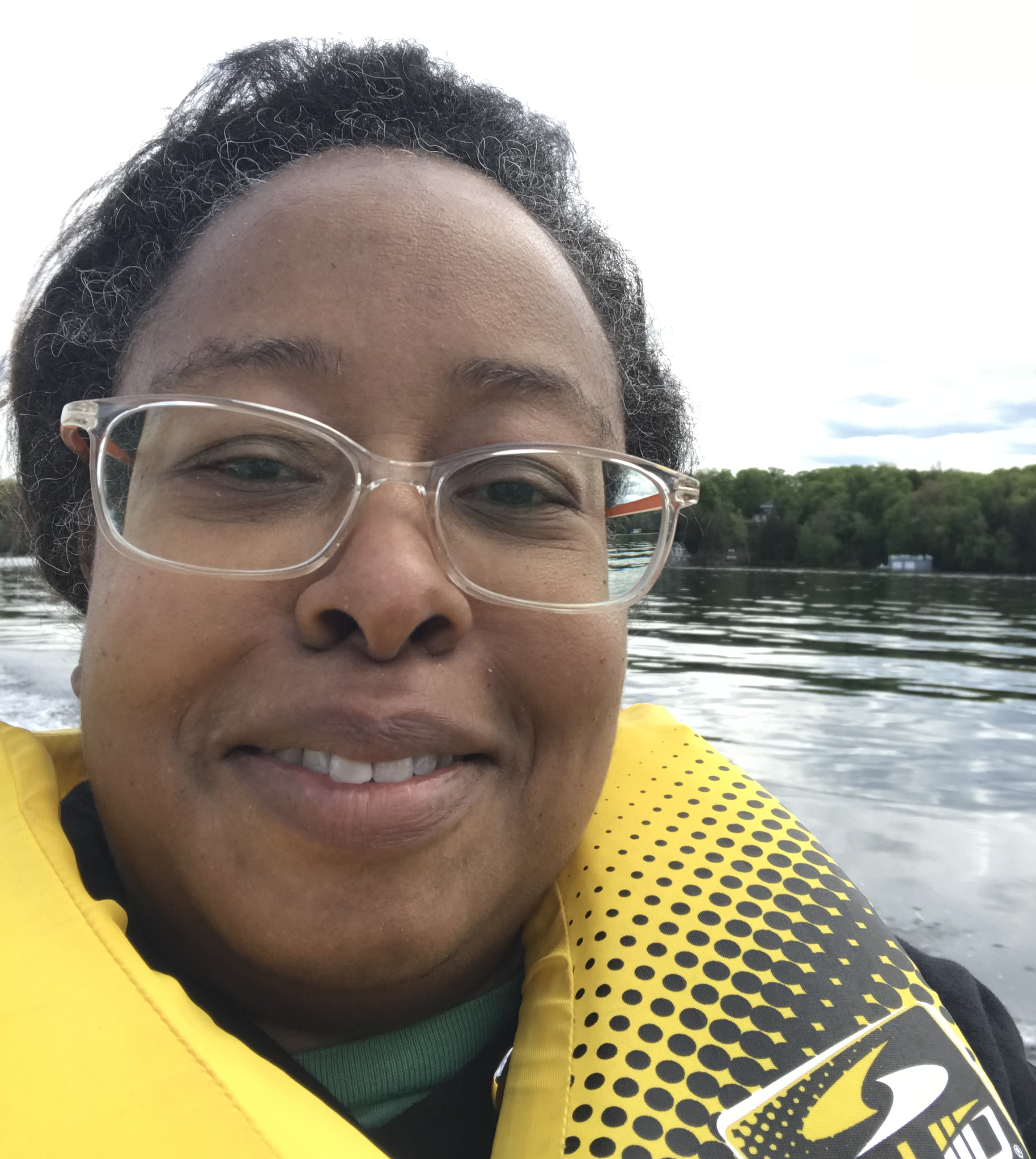 Llonella porte un gilet de sauvetage jaune et est assise sur un bateau à INCA Lake Joe.