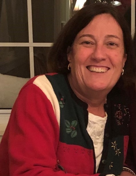 Stephanie Wilsack wearing a Christmas sweater and smiling 