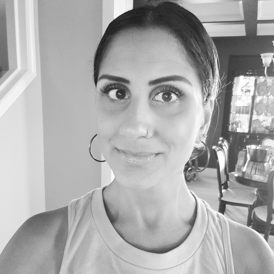 A personal black and white headshot of Sara. She smiles at the camera.