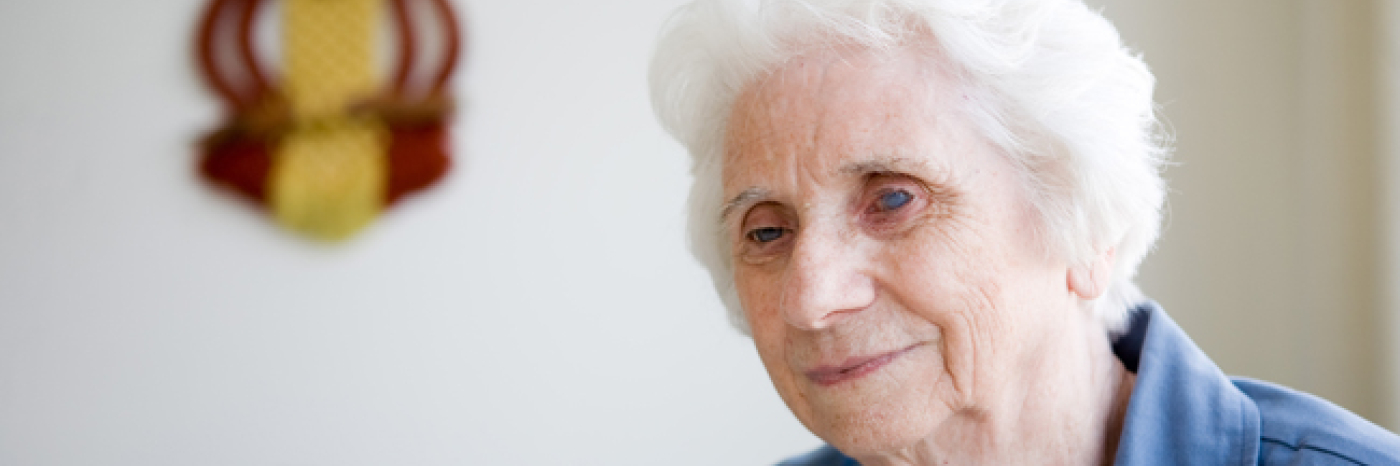 Elderly woman smiling sitting while sitting down. 