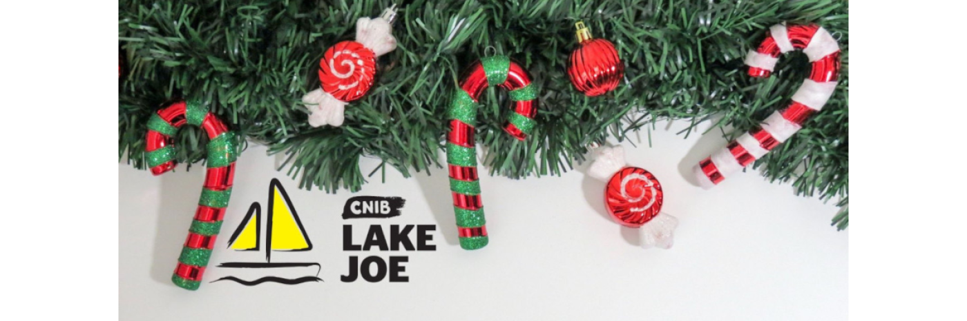 Le logo d'INCA Lake Joe sous une branche de sapin avec des cannes de bonbon et des ornements.