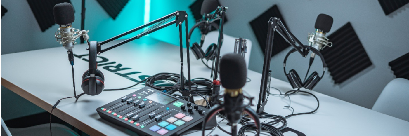 Un bureau sur lequel se trouve le matériel de baladodiffusion (microphones, écouteurs, câbles, mélangeur). 