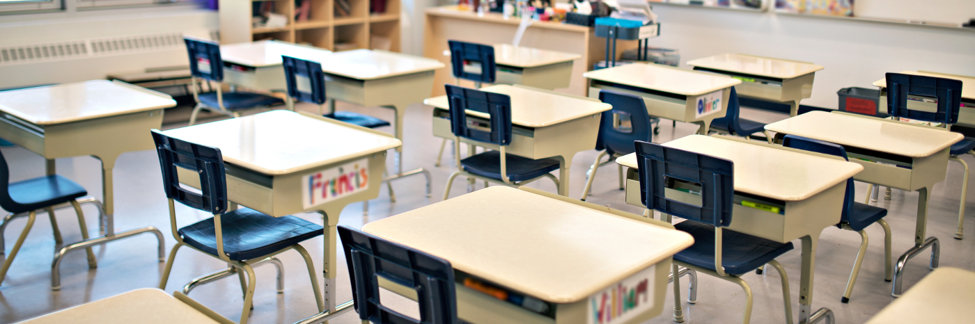 Une salle de classe d'école primaire avec des rangées de bureaux vides. 