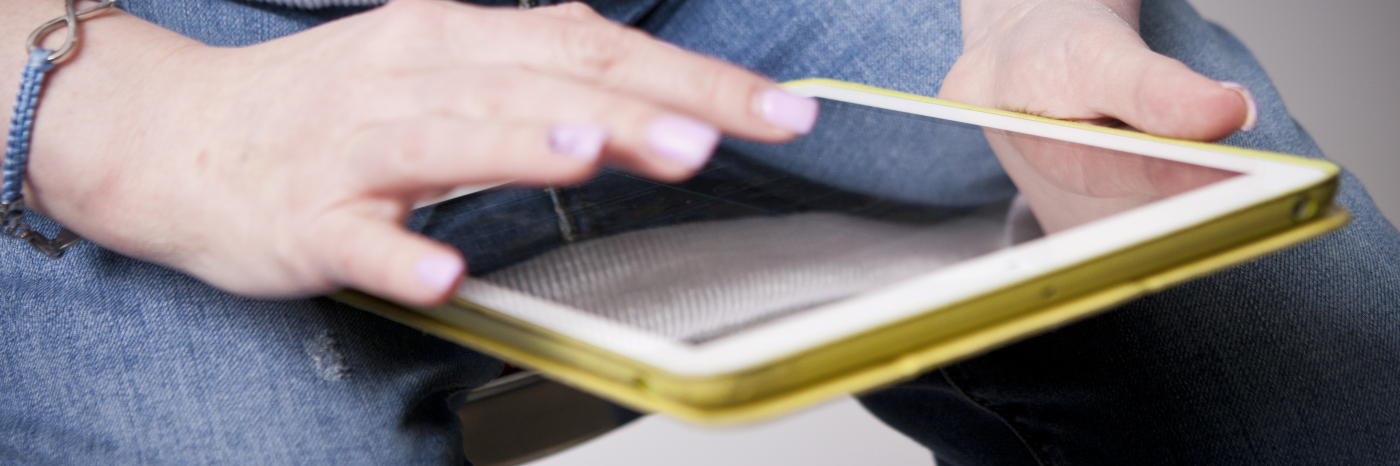 Une femme tient une tablette iPad sur ses genoux