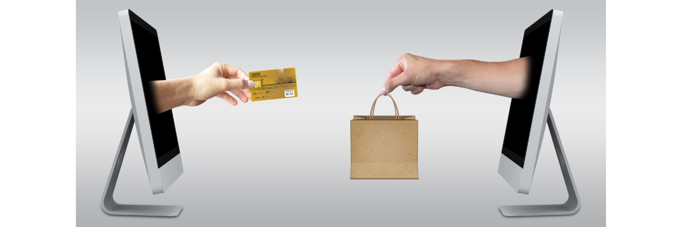 Deux ordinateurs de bureau avec des images photoshoppées de mains sortant des moniteurs. Sur l'écran de l'ordinateur de gauche, une main est tendue et tient une carte de crédit. Sur l'ordinateur de droite, une main tendue tient un sac à provisions. 