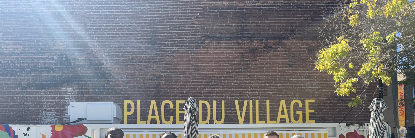 Un groupe de Sept personnes qui posent sur une photos et on voit derrière une écriture en jeune jaune : Place du village