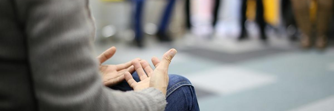 Gros plan des mains d'une personne qui parle dans un groupe de soutien.