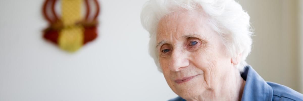 Elderly woman smiling sitting while sitting down. 