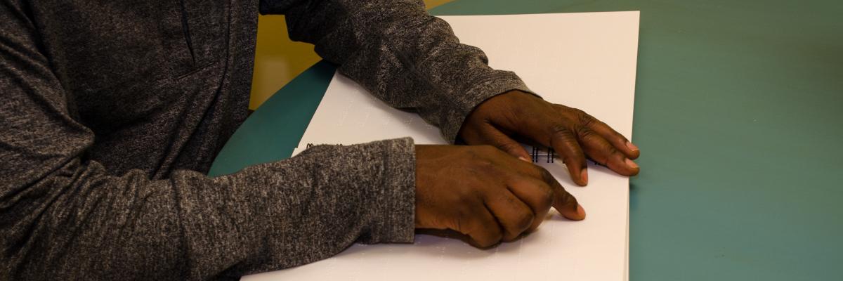 un homme lit le braille