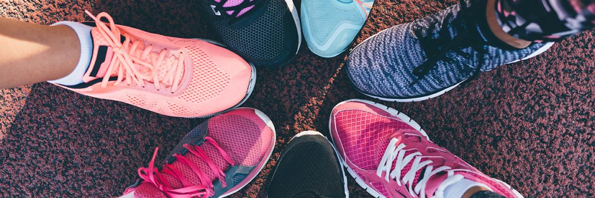 Les jambes de personnes portant des chaussures de course colorées formant un cercle