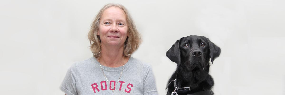 A woman and her black Labrador/Golden Retriever guide dog.