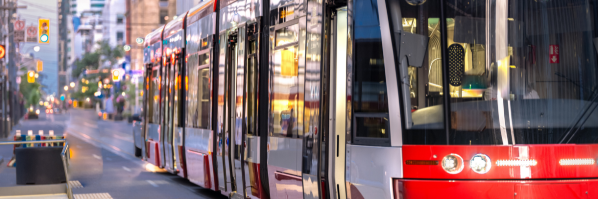 Un tramway circule dans une rue animée de la ville et s'approche d'un arrêt. 