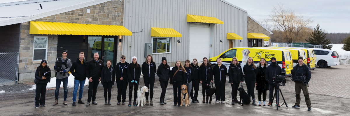 L’équipe des Chiens-guides d’INCA et l’équipe du documentaire posent pour une photo de groupe à Carleton Place, devant le campus canin des Chiens-guides d’INCA.