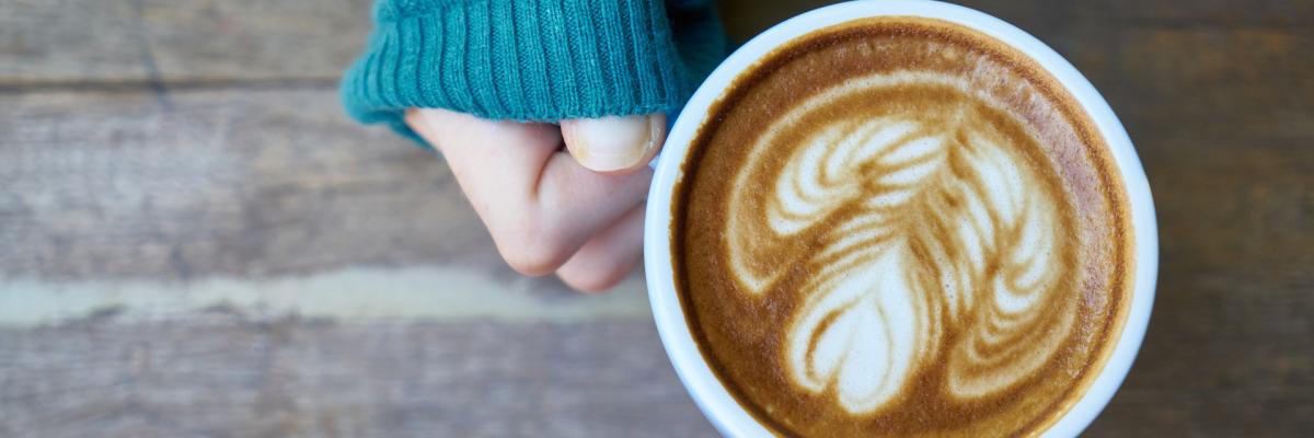 Plan de haut d'une main qui tient une tasse de café