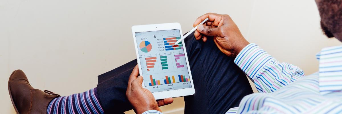 A man uses an iPad to look at graphs.