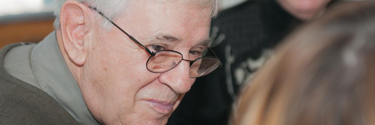 Un homme ayant une basse vision échange et discute dans un groupe de soutien en souriant.
