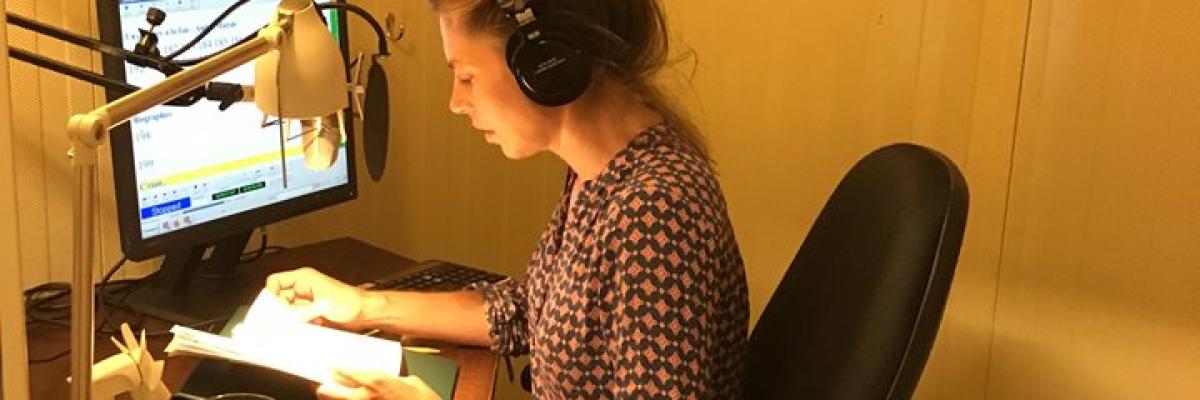 Noémie Godin-Vignault, volunteer, recording an audio book in a studio.