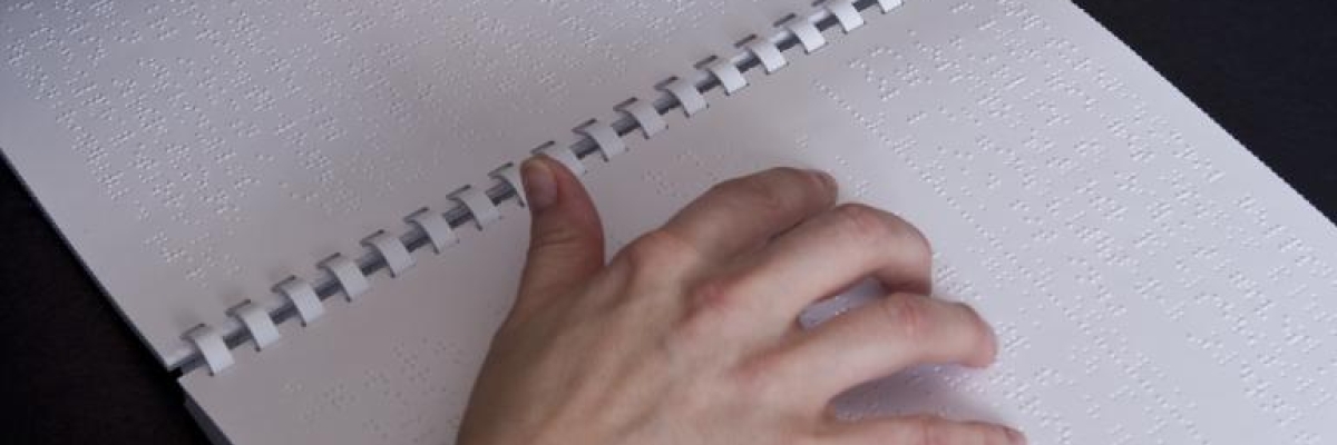une main lit du braille