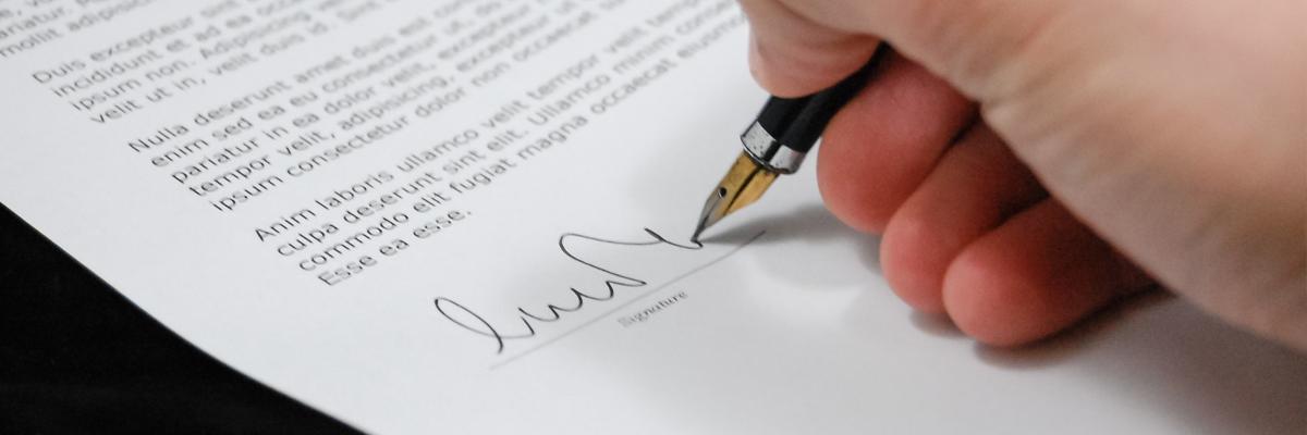 Une main qui signe un document.