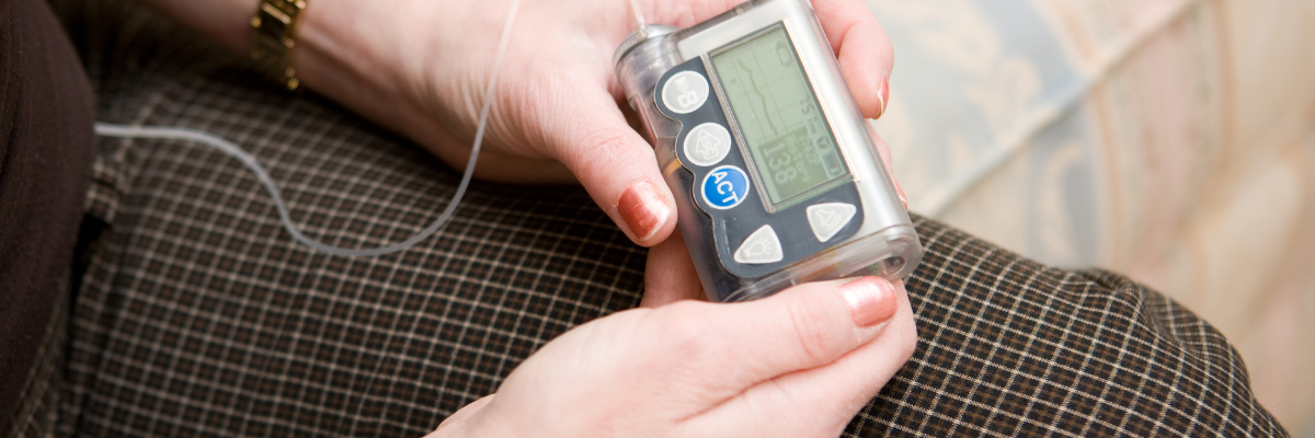 A woman holds an insulin pump.