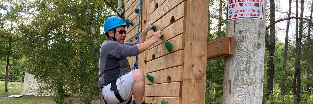 A participant scales the climbing tower at CNIB Lake Joe. 