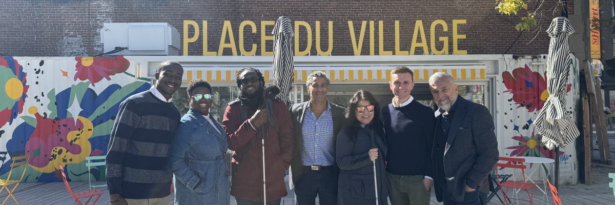 Un groupe de Sept personnes qui posent sur une photos et on voit derrière une écriture en jeune jaune : Place du village