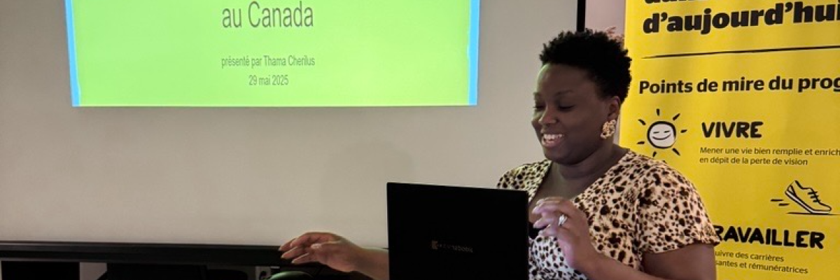 Thama présente un Powerpoint, assise derrière un ordinateur et un micro.