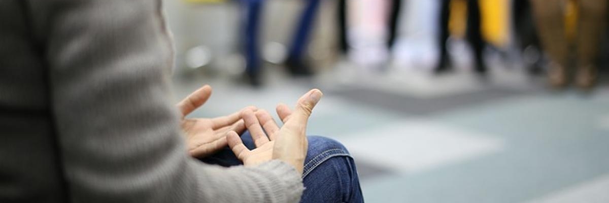 Gros plan des mains d'une personne qui parle dans un groupe de soutien.