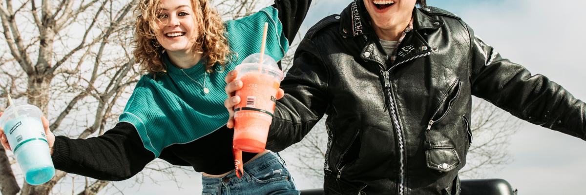 Une fille et un garçon dans la neige avec leur boisson «slush»