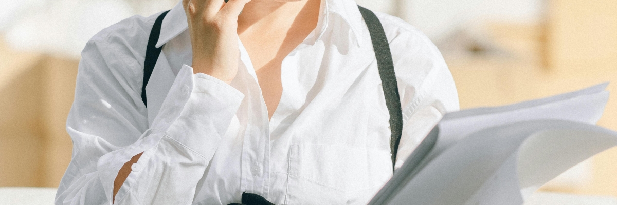 Une jeune femme en tenue professionnelle au téléphone.