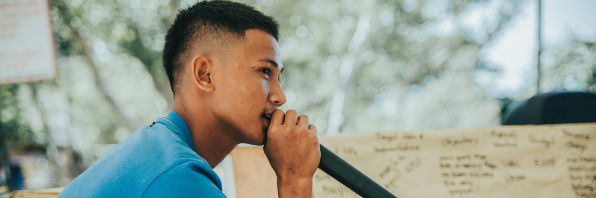 Un jeune homme qui parle au micro