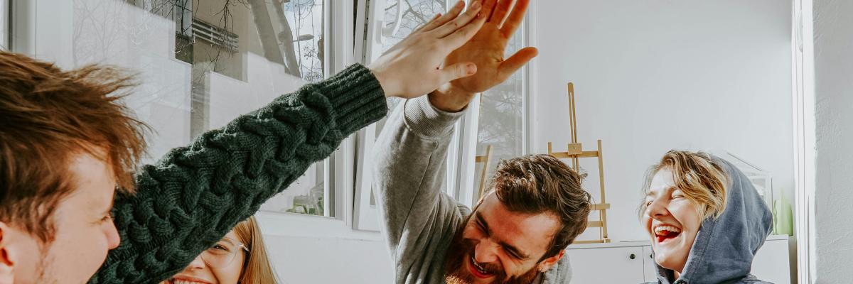 quatre jeunes qui rient avec leurs boissons chaudes dans un atmosphère décontracté