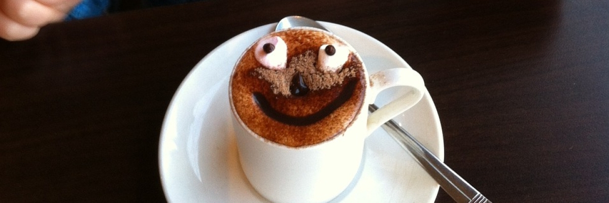 Un enfant en train de faire une grimace devant son chocolat chaud.
