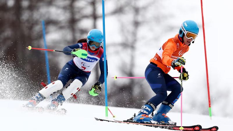 un athlète skie avec son guide voyant. Source : Olympics.com