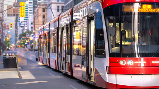 Un tramway glisse le long d'une rue animée de la ville et s'approche de l'arrêt.