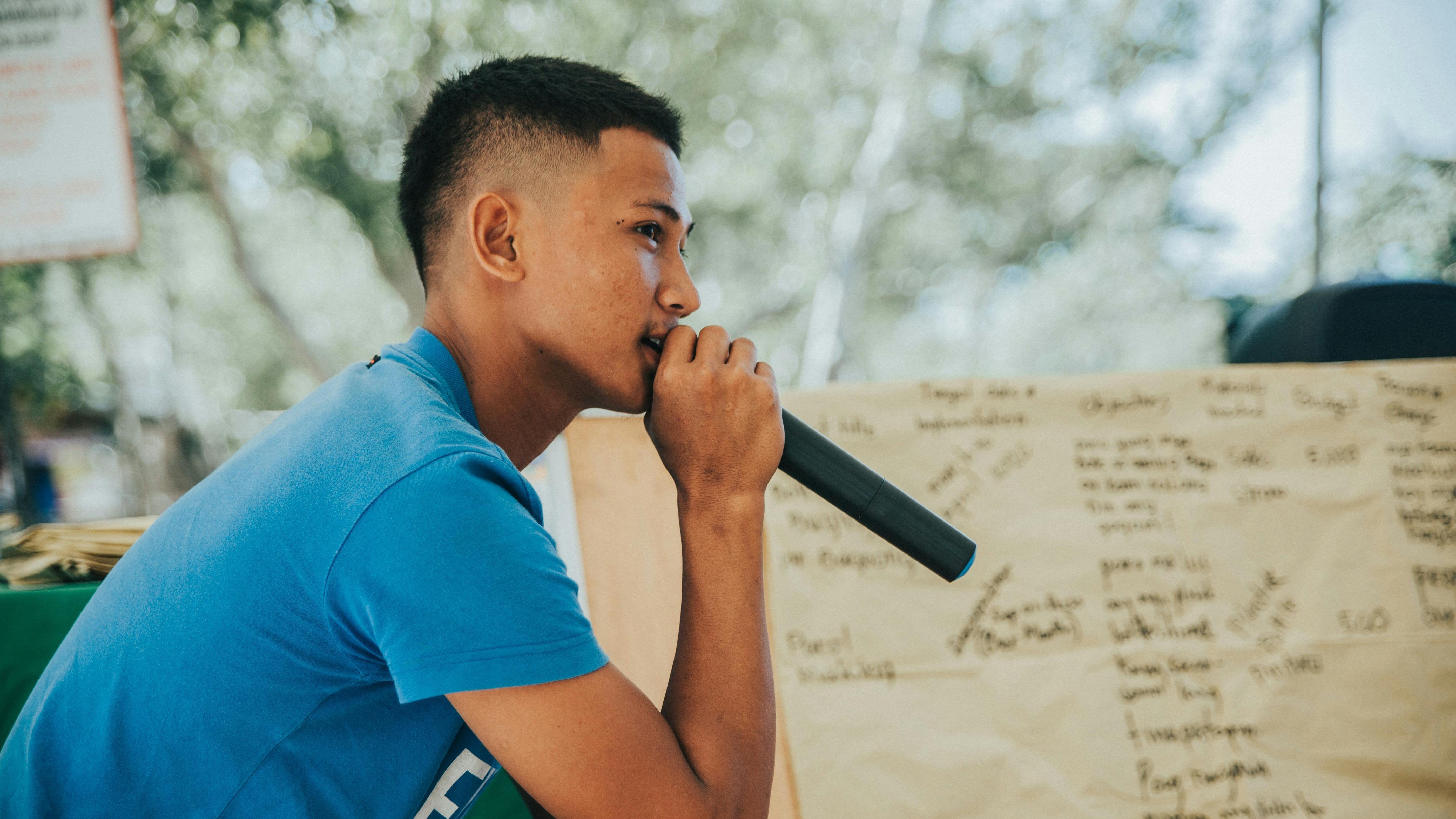 Un jeune homme qui parle au micro.