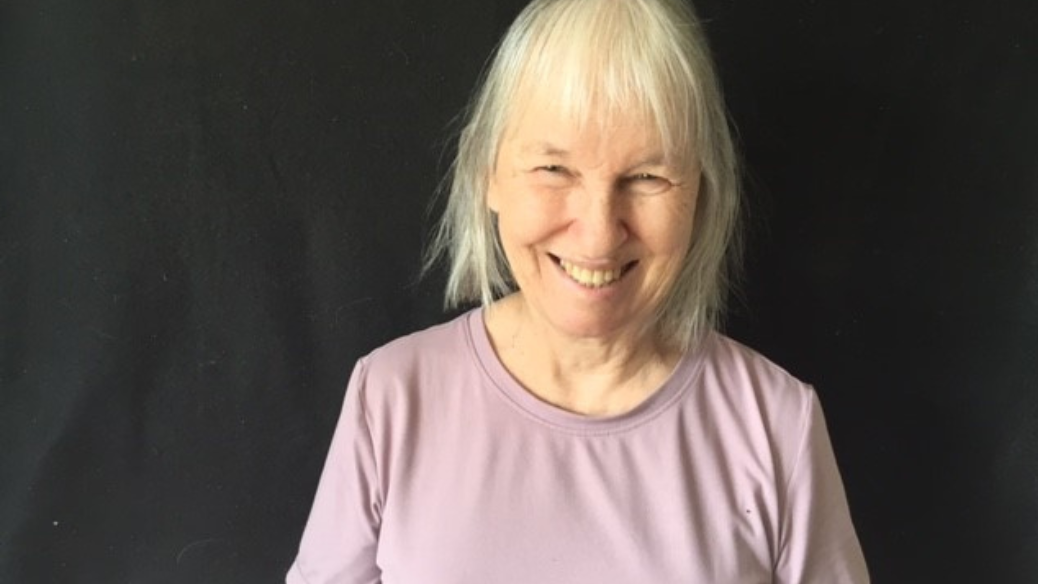 Une photo de tête de Brenda Macalister souriant devant un fond noir.
